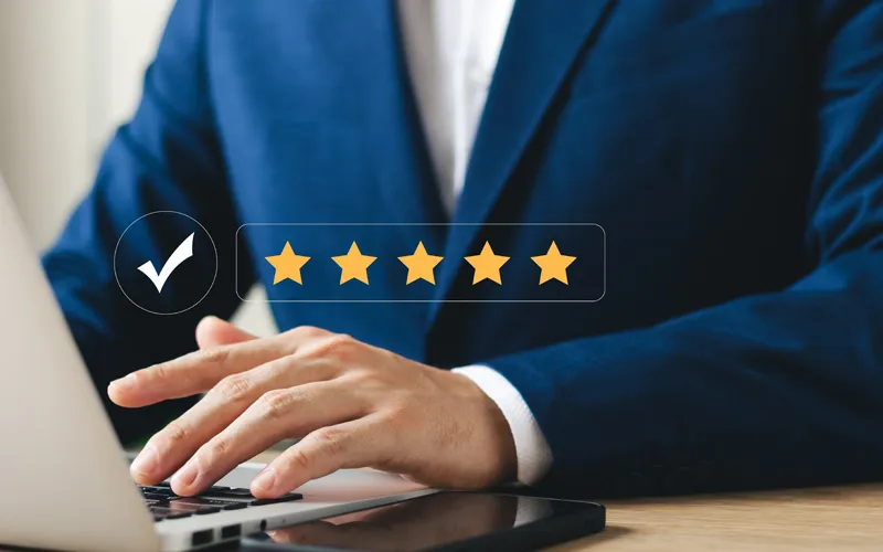 Una mano che regge una lente su una pagina web con recensioni e citazioni in evidenza